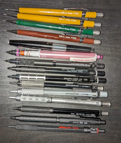 A collection of mechanical pencils lined up on a desk